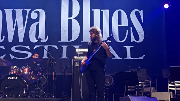 Mateusz Pawelec na scenie Rawa Blues Festival w niebieskim świetle