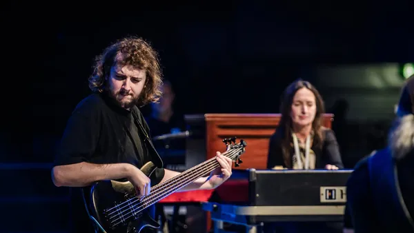 Mateusz Pawelec z gitarą basową na scenie 43. Rawa Blues Festival w Spodku, obok klawiszowczyni przy organach